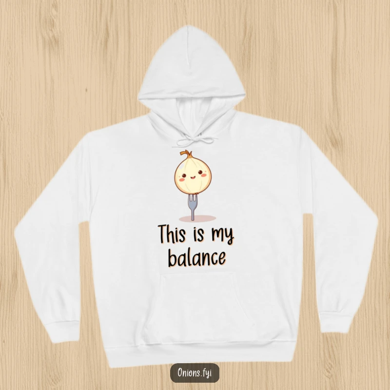 Funny balancing onion hoodie, a round onion character comically balanced on a tiny fork, comfortable food-themed apparel.